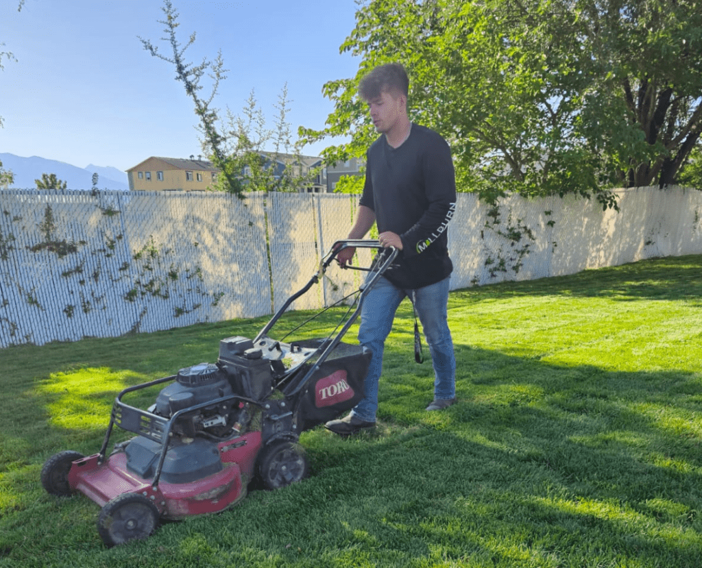 Millburn Lawn and Landscape Employee mowing a lawn