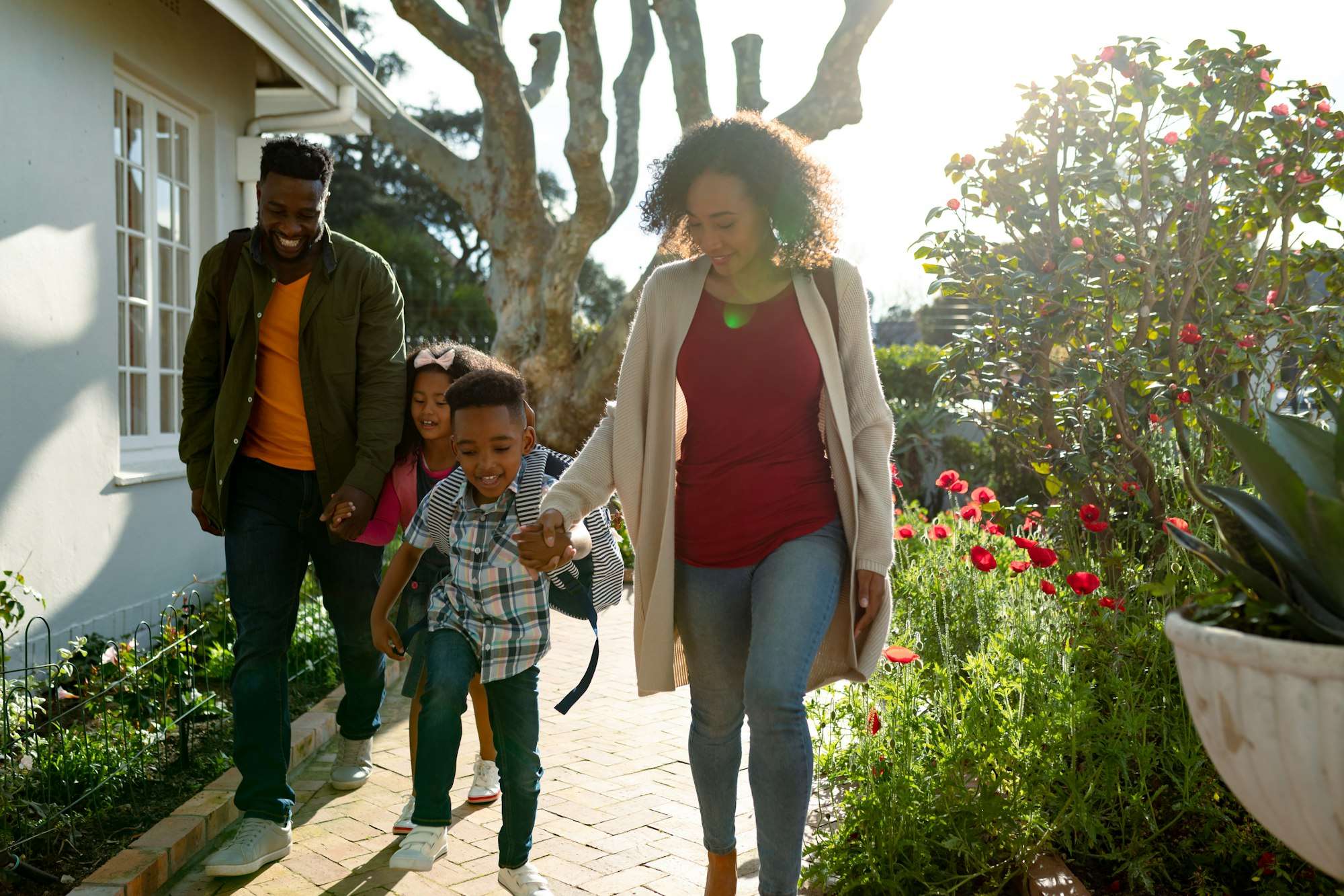 Happy african american family holding hands and walking outside ...