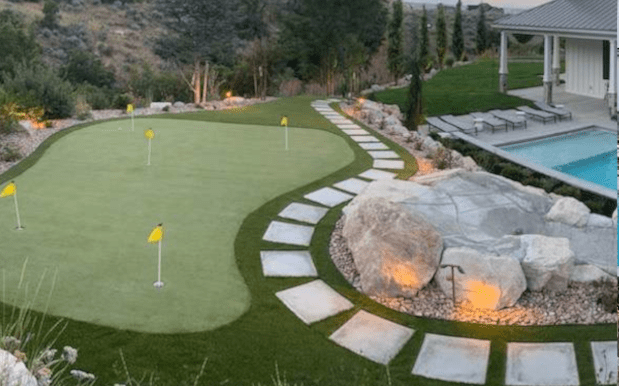 Luxury landscape featuring a putting green, stone path, and pool area in Utah.