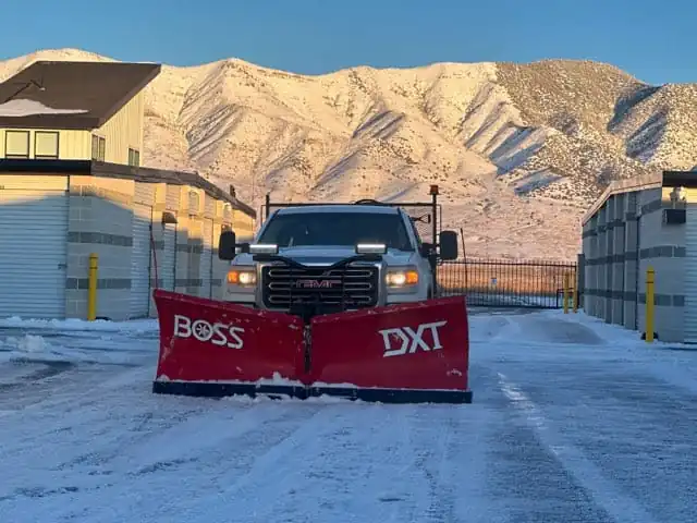 Commercial snow plow clearing a Utah property