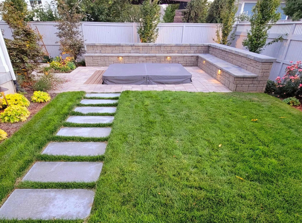 A dense row of Emerald Green Arborvitae trees forming a tall privacy hedge along a suburban Utah backyard fence line
