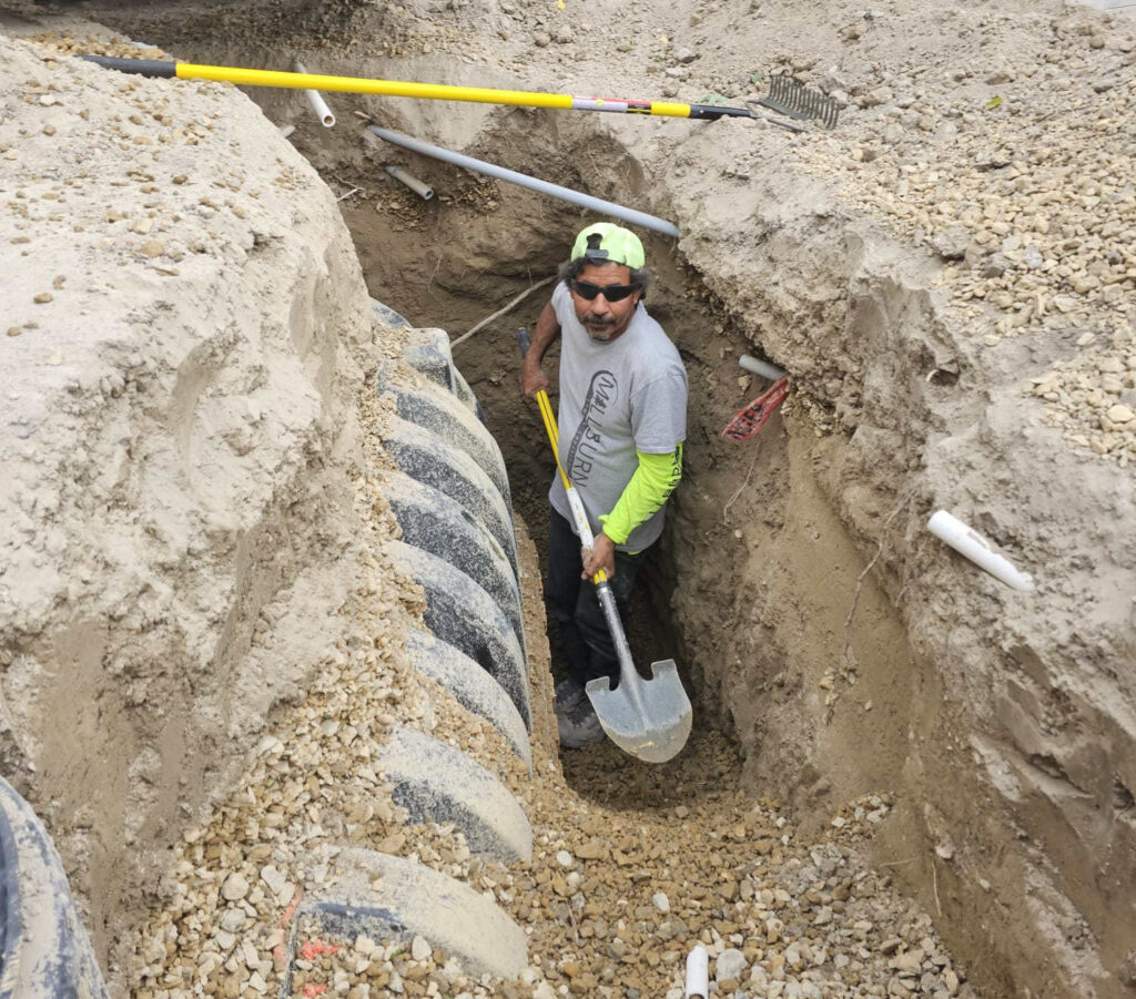 Landscape designer reviewing grading plan for residential yard drainage in Bluffdale Utah