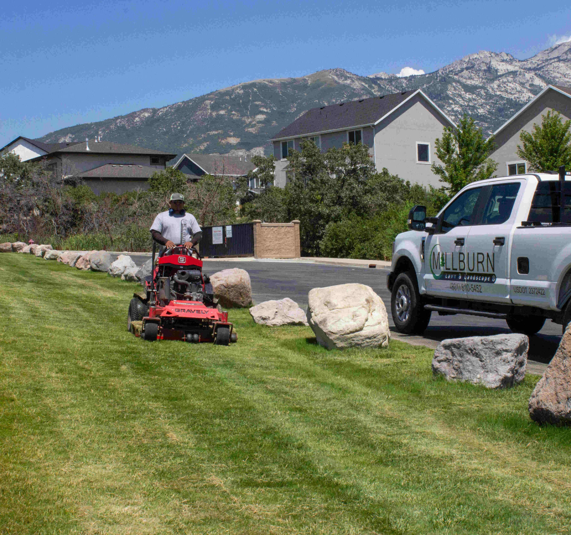 A professional landscaping crew maintaining HOA common area grounds in a Saratoga Springs Utah neighborhood with mountain views