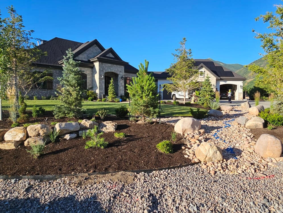 Mature backyard design in Eagle Mountain Utah with stone patio and native plantings