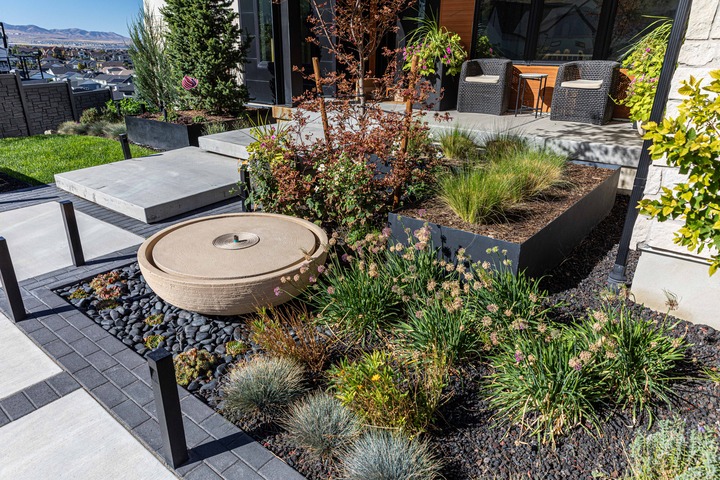 Xeriscape planting bed in Sandy, Utah with Blue Oat Grass, Russian Sage, Apache Plume and river rock — Millburn Lawn & Landscape