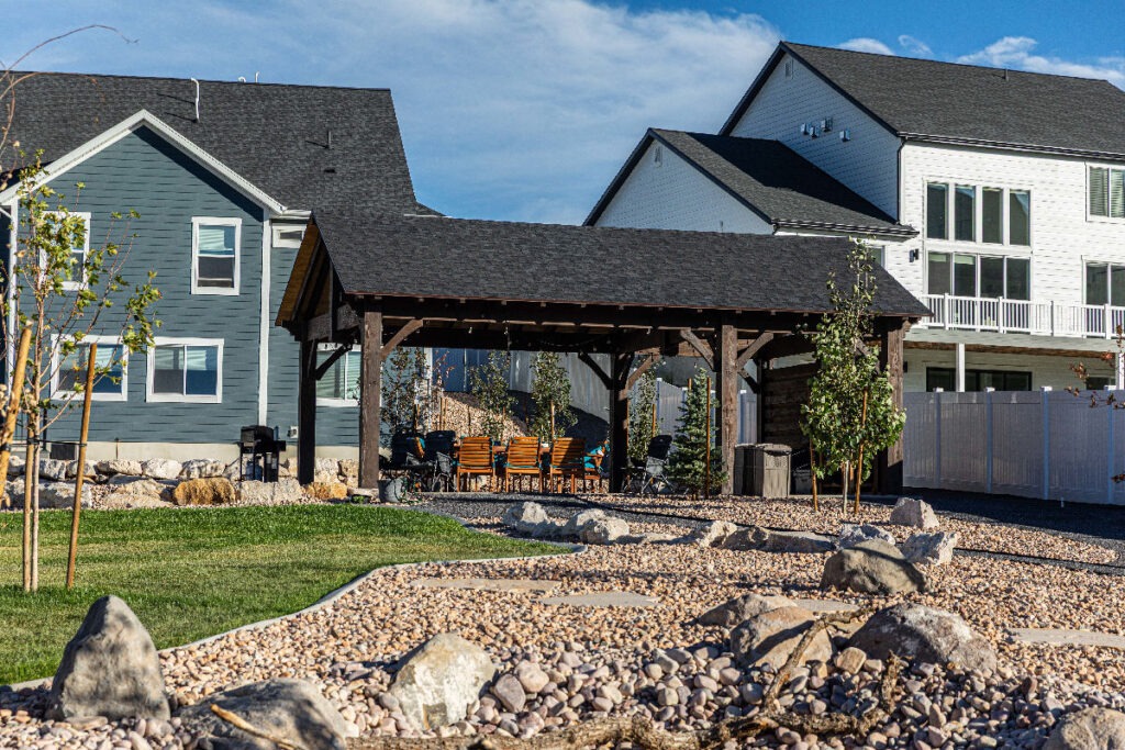 A Millcreek Utah small urban backyard designed with defined outdoor zones a pergola structure and layered planting that makes the space feel twice its actual size
